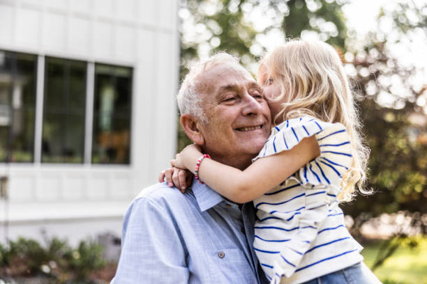 Grandfather and daughter in front of suburban home